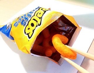 Chopsticks being used to eat Cheetos.
